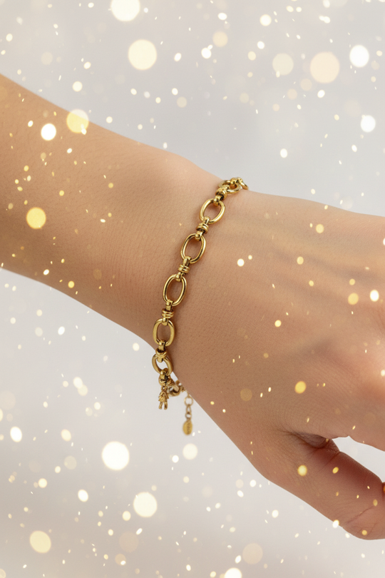Arm met gouden schakelarmband en sparkles