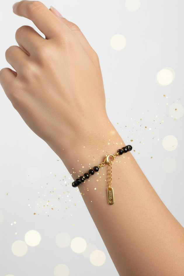 Arm met zwarte kralenarmband en sparkles