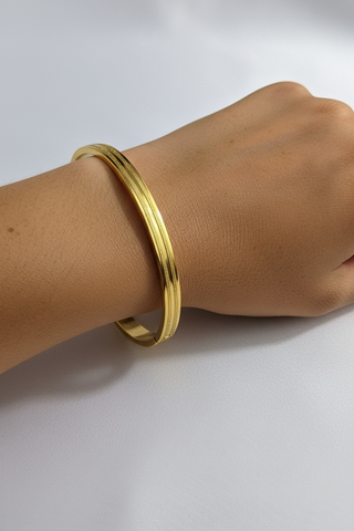Echte arm met gouden gestreepte bangle