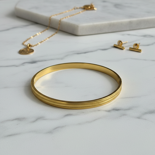 Gouden gestreepte bangle op marmer