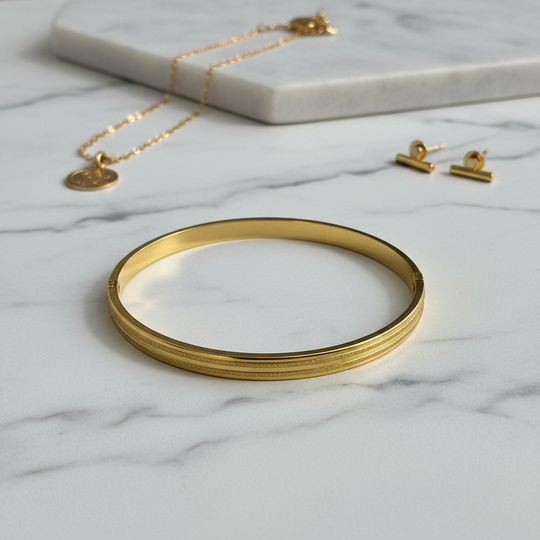 Gouden gestreepte bangle op marmer