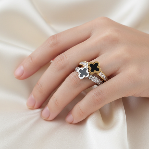 Model draagt goud en zilver klavervier ringen zwarte emaille