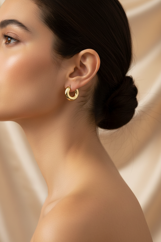 Model draagt gouden chunky creool oorbellen