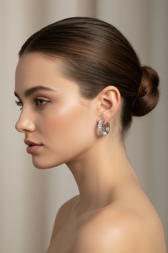 Model draagt zilveren creool oorbellen met baguette zirkonia