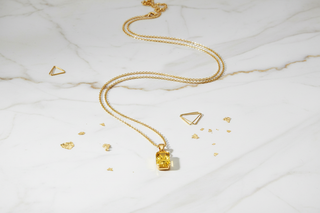 Gouden ketting op marmeren ondergrond - luxe flat lay
