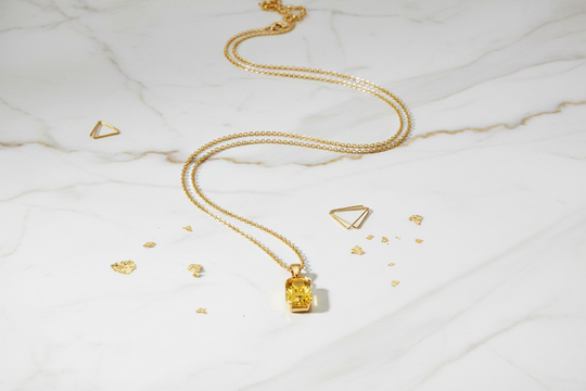 Gouden ketting op marmeren ondergrond - luxe flat lay