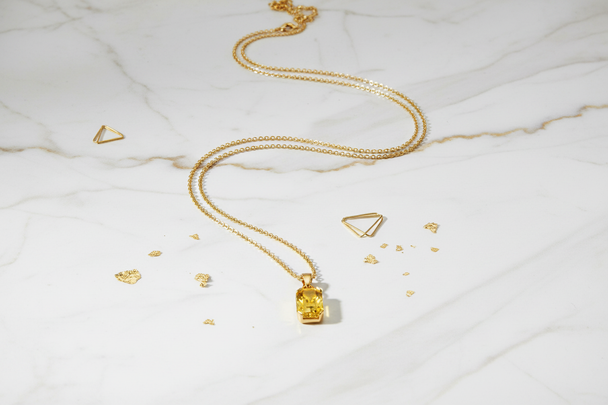 Gouden ketting op marmeren ondergrond - luxe flat lay