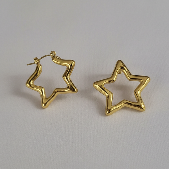 Detail shot gouden ster creool oorbellen gedraaid