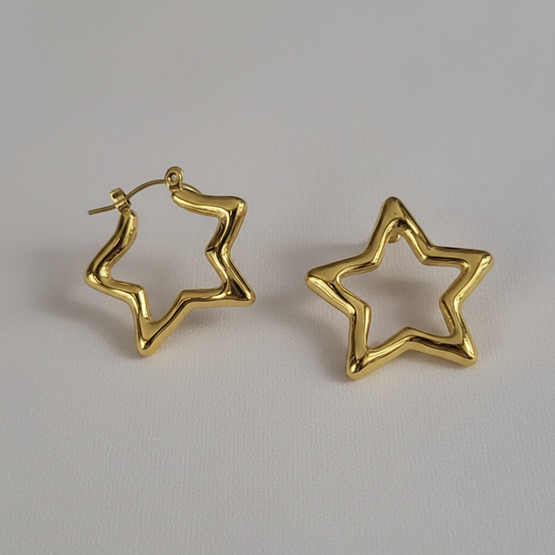 Detail shot gouden ster creool oorbellen gedraaid