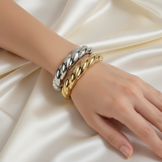 Model draagt zilver en goud chunky twisted armbanden