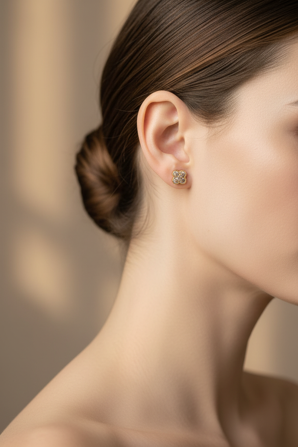 Model draagt gouden klaver oorknopjes met zirkonia