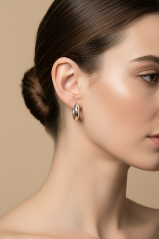 Model draagt zilveren chunky creool oorbellen