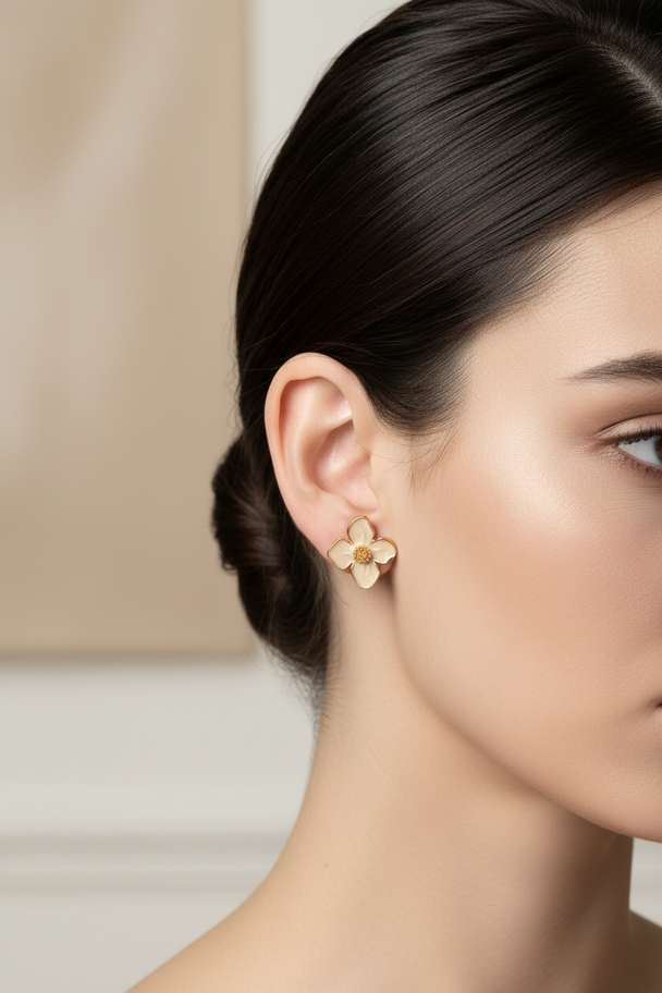 Model draagt bloem oorknopjes beige goud
