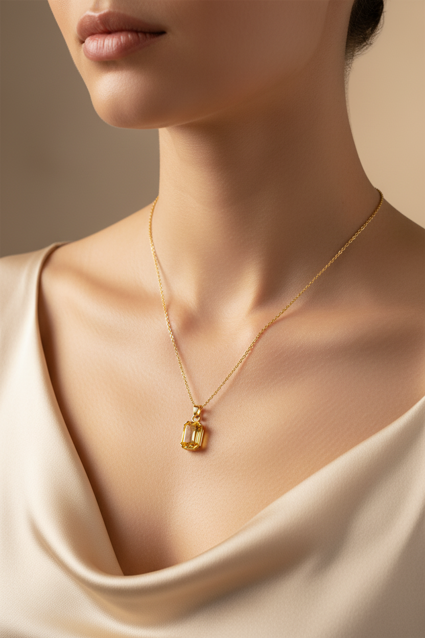 Close-up model met gouden ketting en gele kristal hanger