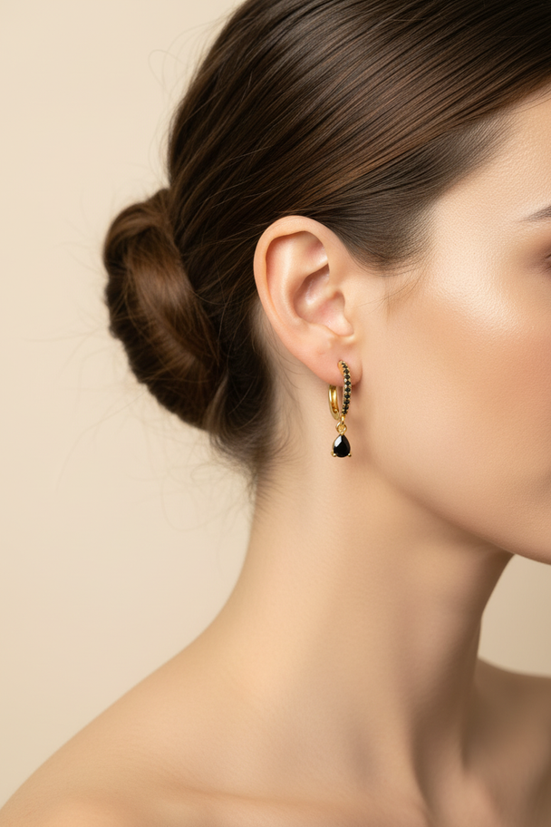 Model draagt gouden zwarte druppel oorbellen