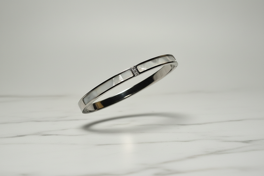 Zilver armband zwevend op wit marmer