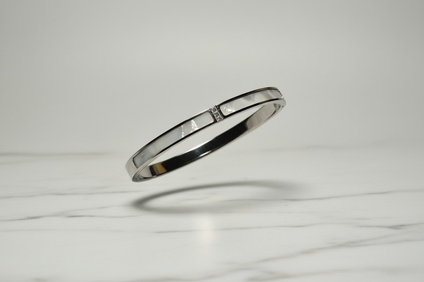 Zilver armband zwevend op wit marmer